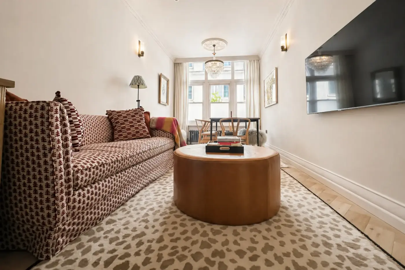 Refurbished living room with patterned sofa and wall-mounted TV