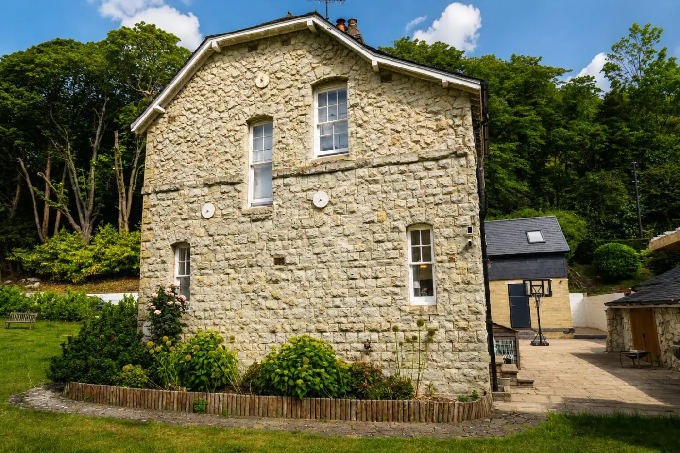 Renovated stone side elevation of the Redhill house with new planting
